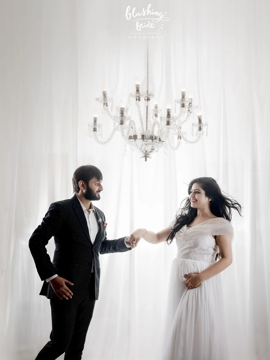Maternity photography by Blushing Bride, an expectant couple photographed against white drapes